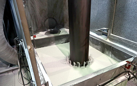 とても深い流動槽にパイプを沈めた瞬間です。パイプのボルト穴から塗料が少し吹き上がる様子が見えます。